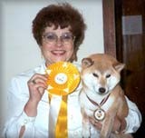 בעלת כלב גזעי מקבלת פרס לאחר זכייה בתחרות כלבים