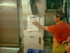 סוחר בשוק פתחת תקווה תולה כרזה של אנונימוס