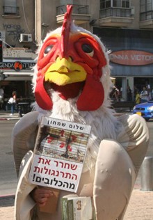 דמות מחופשת כתרנגולת עם מקור קטום וגחון עירום מנוצות בקמפיין נגד כלובי הסוללה.